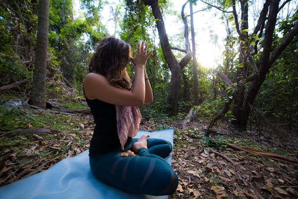 Person practicing yoga in a forest